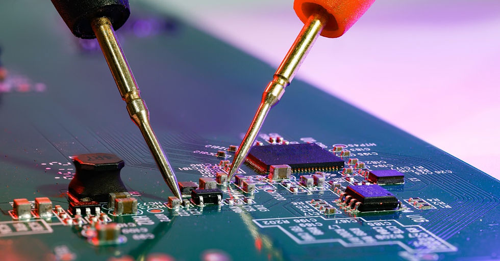 Two metal testing probes touching components on a green circuit board with a square microchip and printed traces.