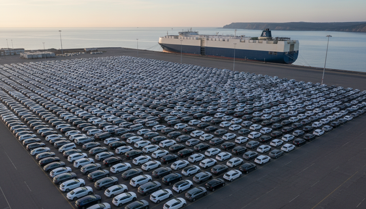 Overhead view of new cars lined up at a shipping port.