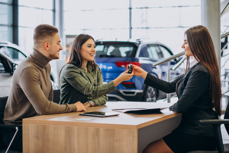 Couple with car keys at the dealership