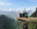 Girls posing on a ledge jutting out of the mountain
