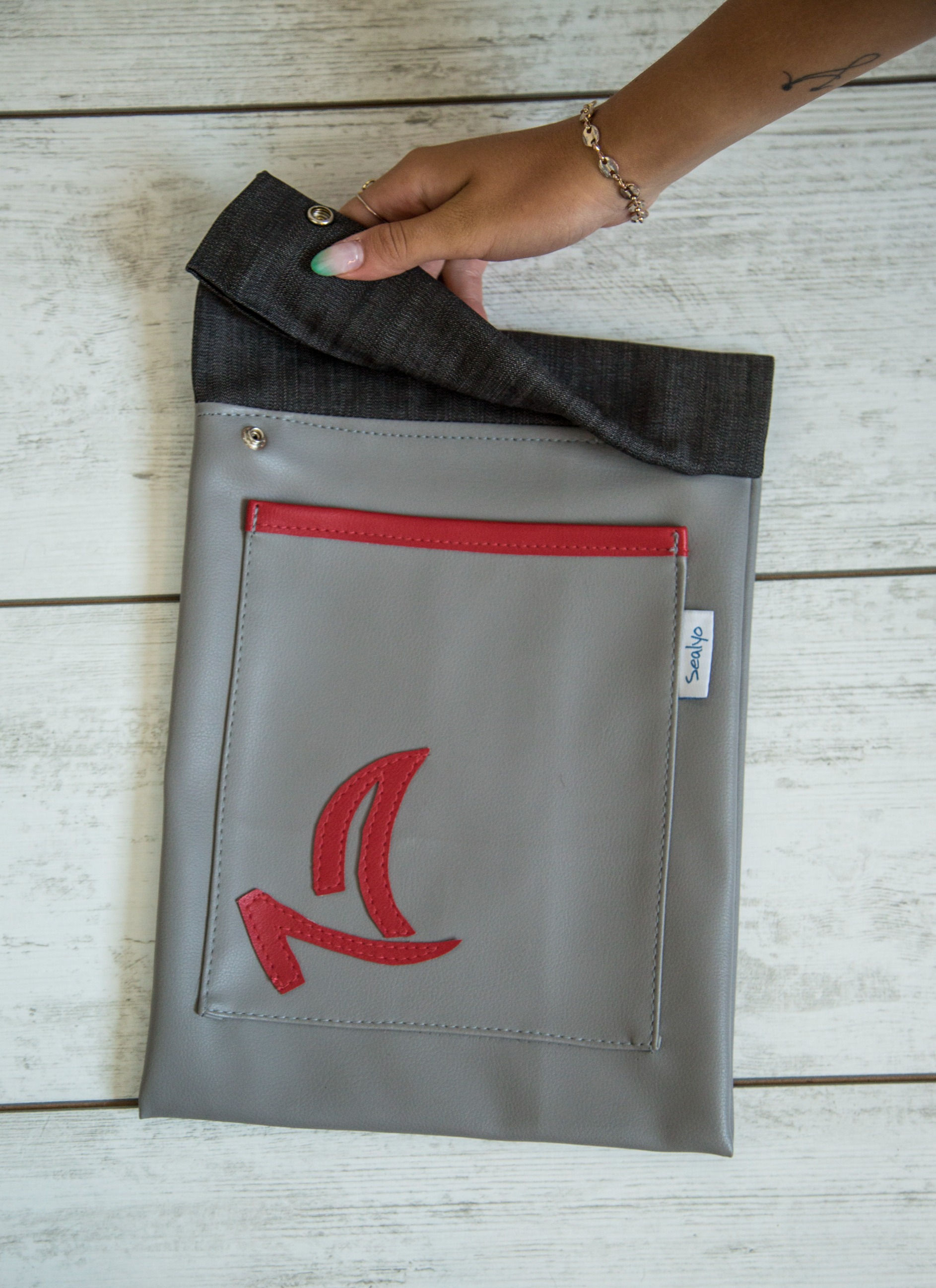 Gray faux leather iPad case with front pocket and nautical sailboat emblem