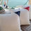 Thumbnail: Set of three white nautical throw pillows with red, navy blue, and black sail-inspired corner details, displayed on a boat de