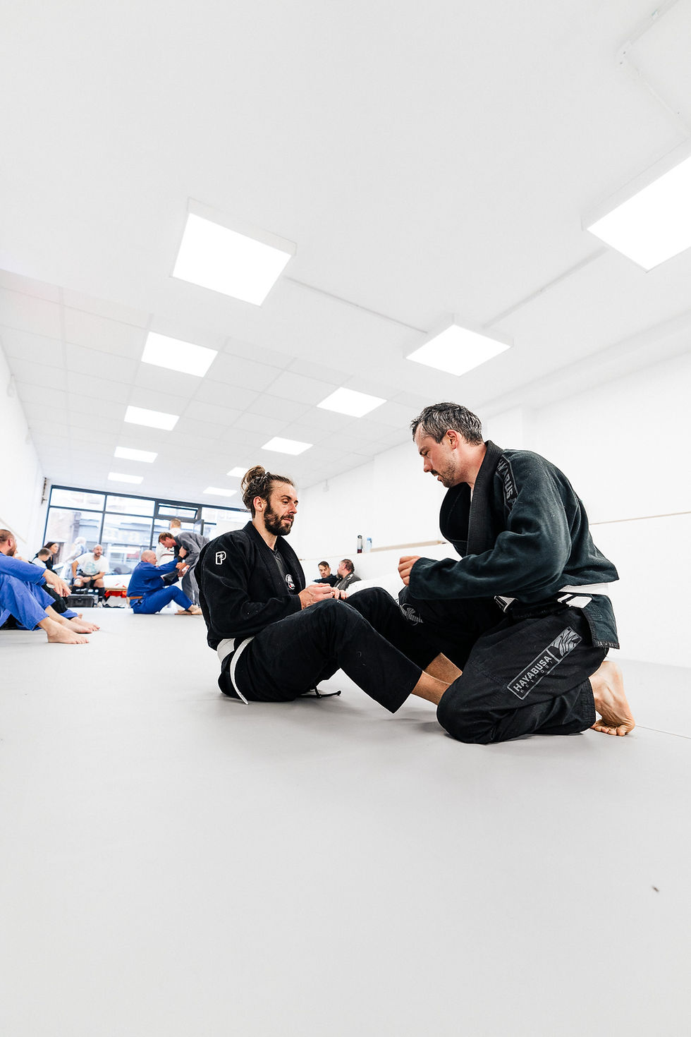 Close-up view of BJJ students practicing techniques on the mat