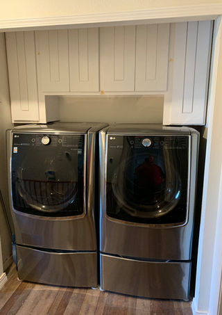Custom white upper cabinets above washer and dryer in Fishers Indiana laundry closet wall - Indiana Fine Woodworking