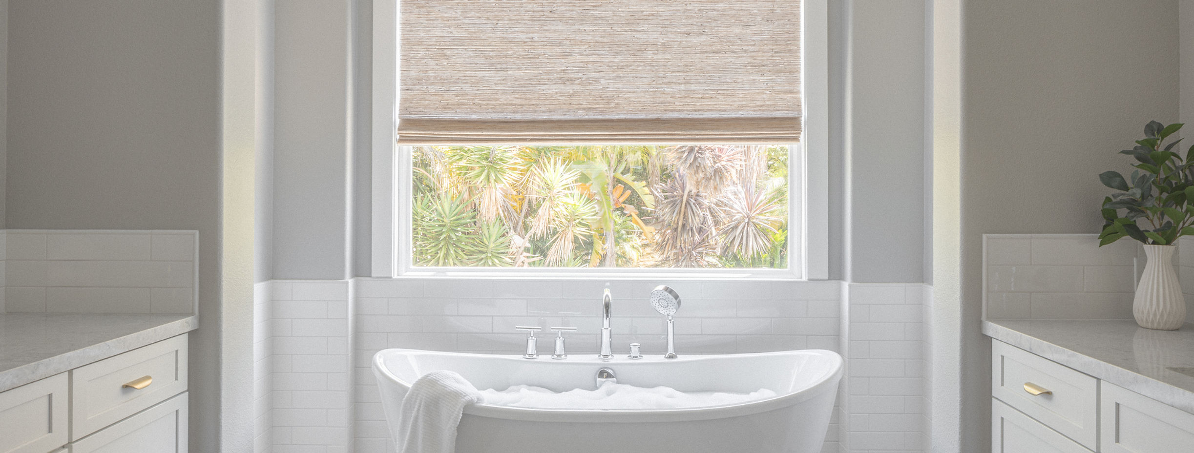 Modern bathroom with white soaking tub and woven shade.