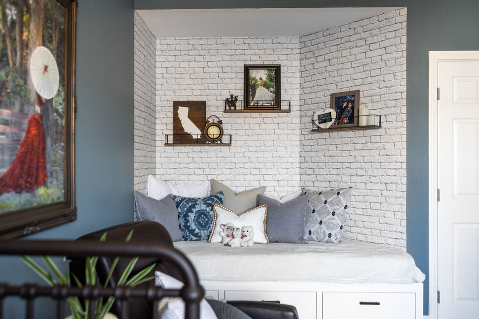 Cozy reading nook with white brick wallpaper and pillows.