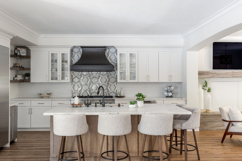 Modern kitchen with white cabinets and black range hood.