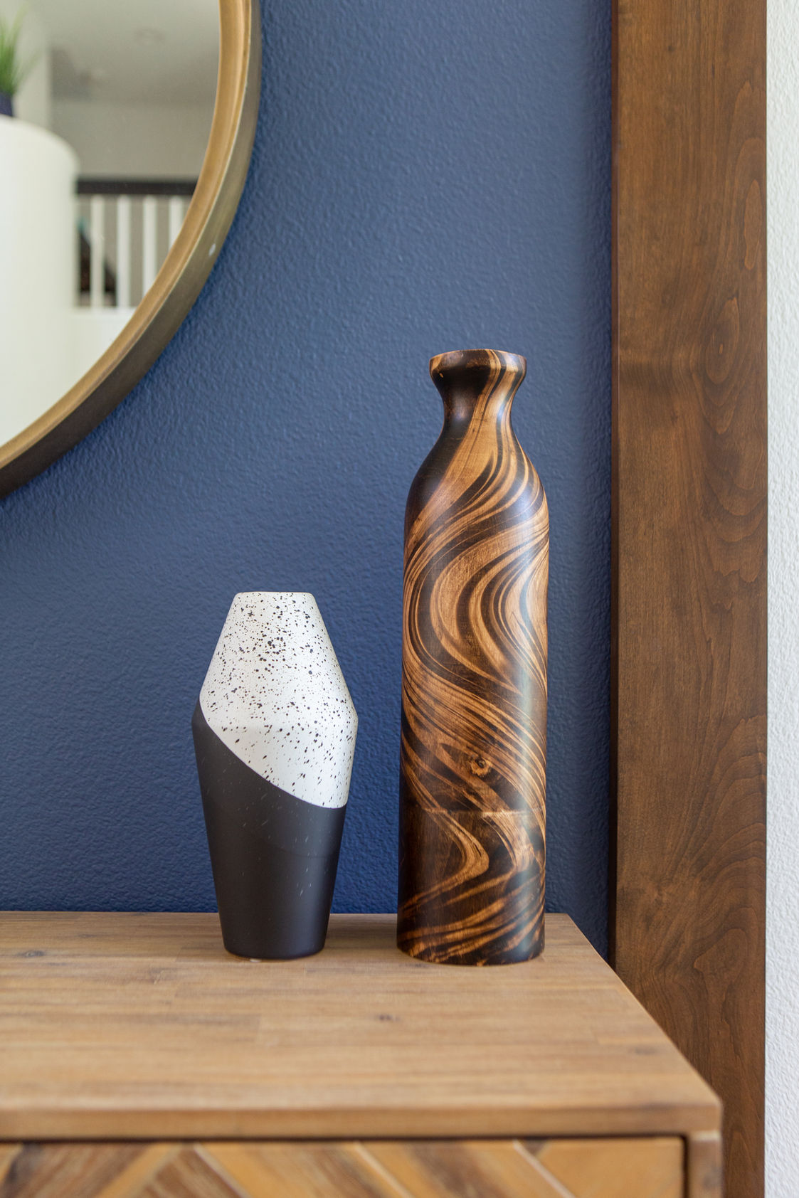 Two decorative vases on a wooden sideboard