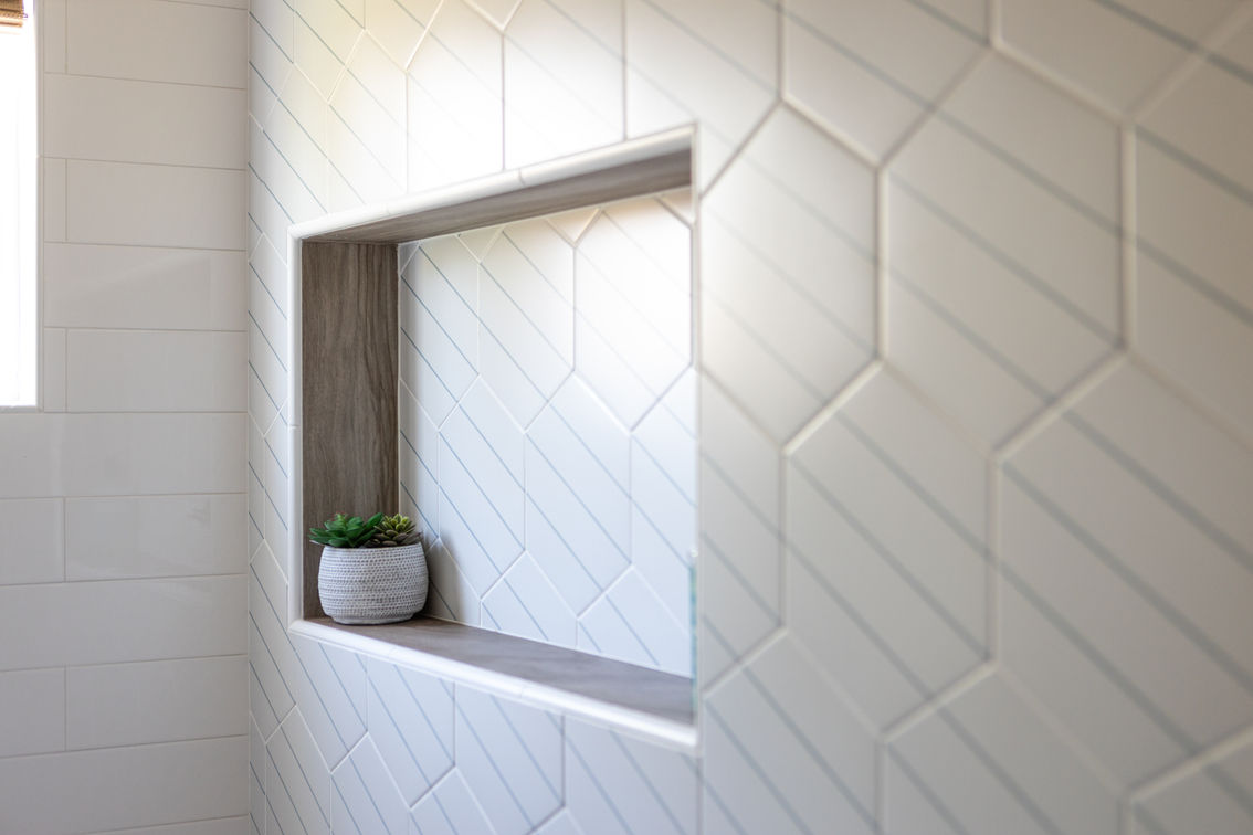Modern white geometric tiled wall with a recessed niche.
