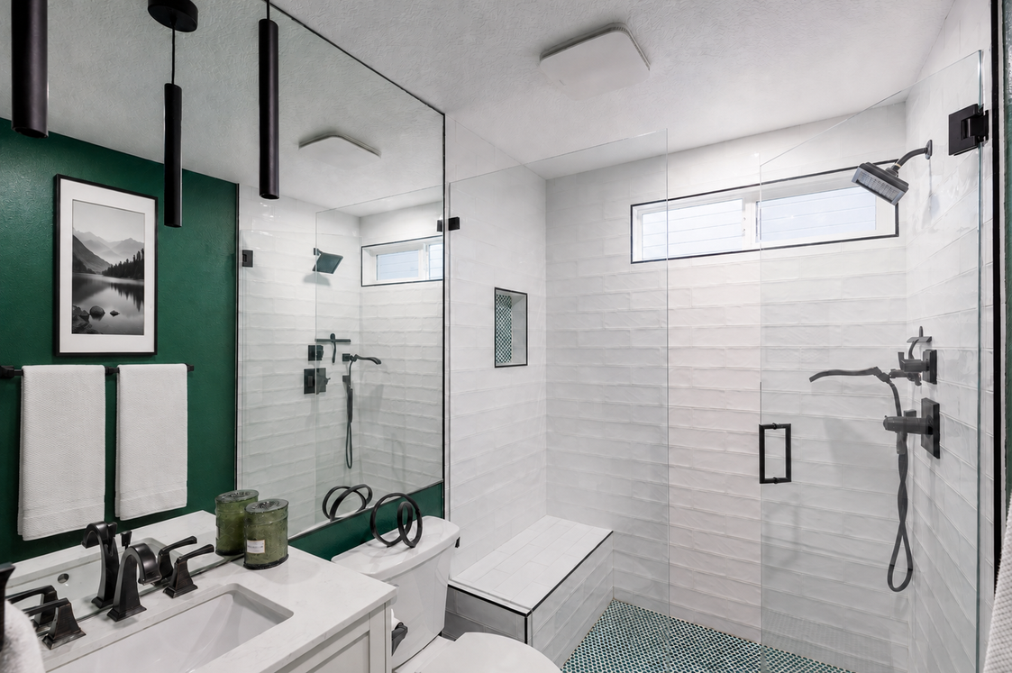 Modern bathroom with green accent wall and walk-in shower