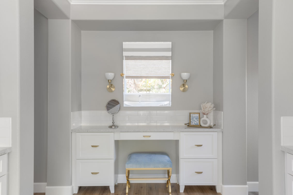 Modern white built-in vanity with blue velvet stool