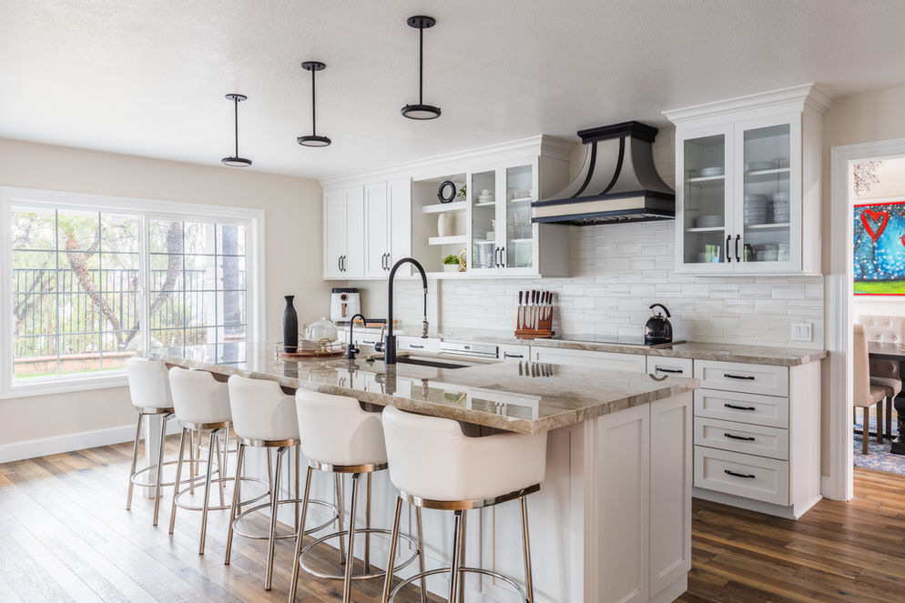 Modern kitchen with white island, bar stools, and range hood