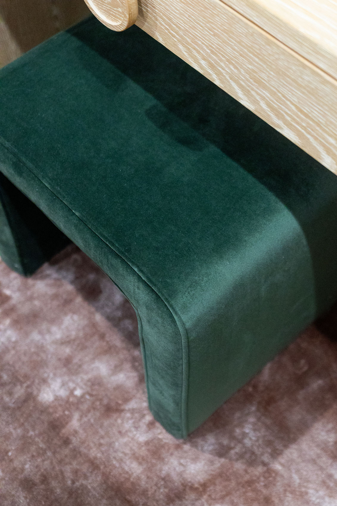 Green velvet curved bench seat detail.