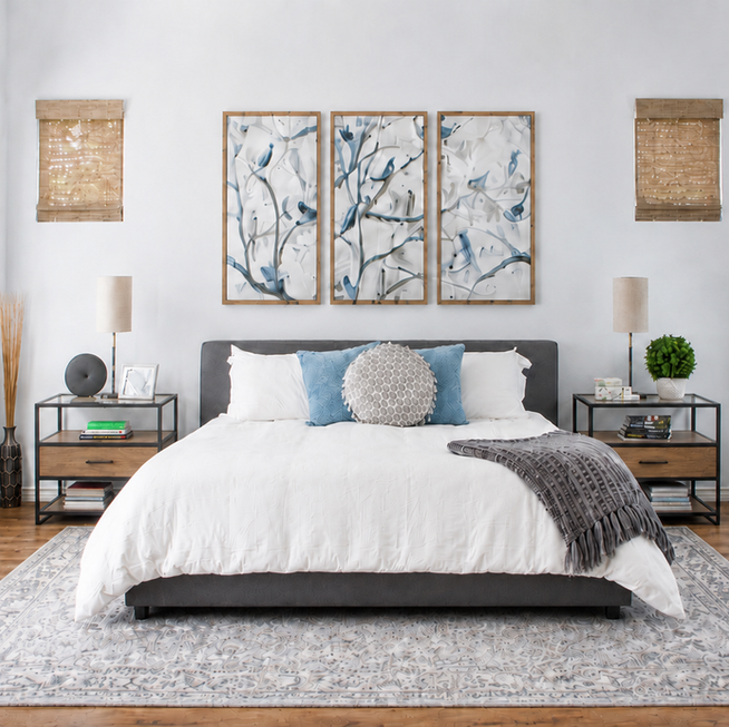 Modern bedroom with white bedding and floral wall art.