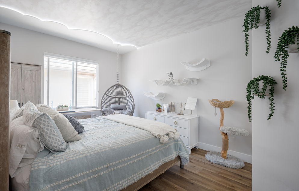 Modern kid's bedroom with hanging chair and cat tree.