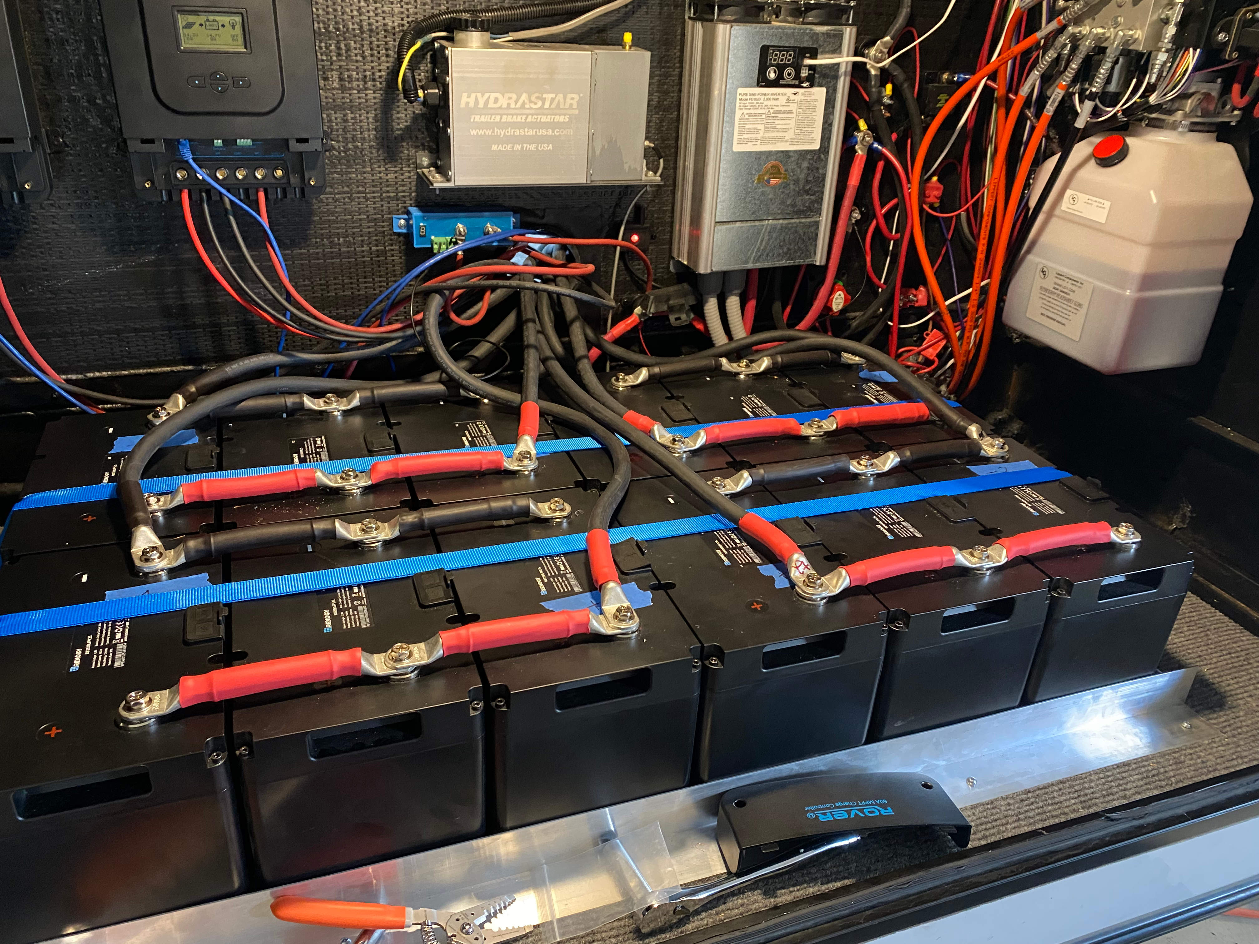 RV electrical and battery compartment with connected battery banks, controllers and wiring