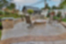 A Stamped Concrete Patio With Firepit & Seating Wall