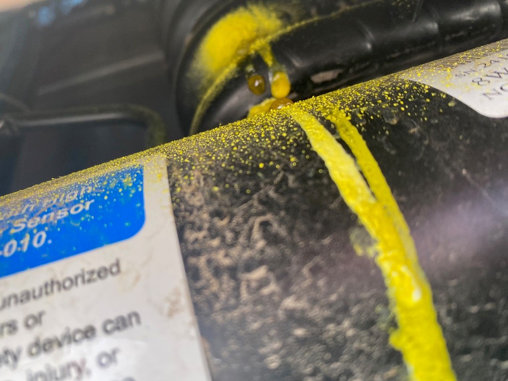 Close-up of an RV heating component housing, label and visible yellow surface residue