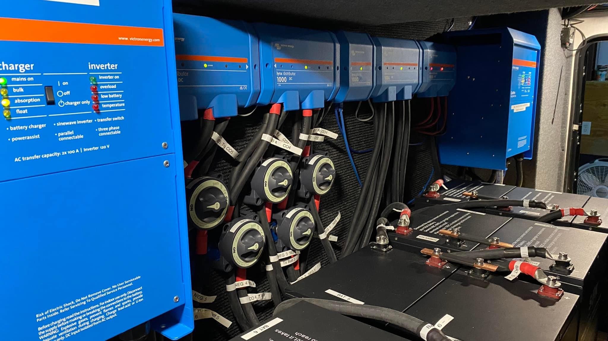 RV specialty electrical compartment with inverter and charging equipment, battery bank and labeled cables
