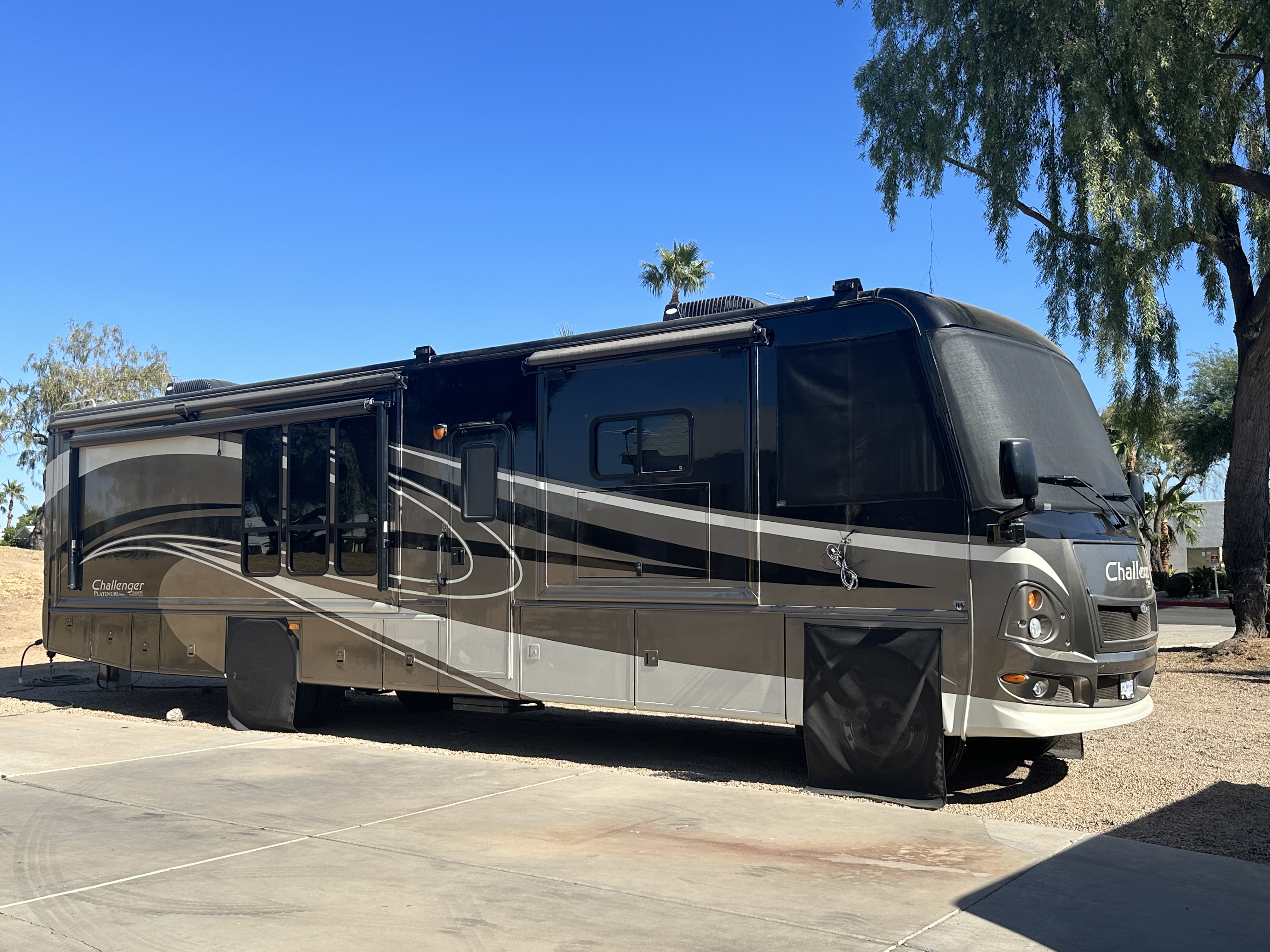 Class A motorhome parked outdoors with its entry door and side compartments visible
