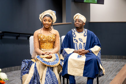 Couple in traditional attire sitting together indoors.