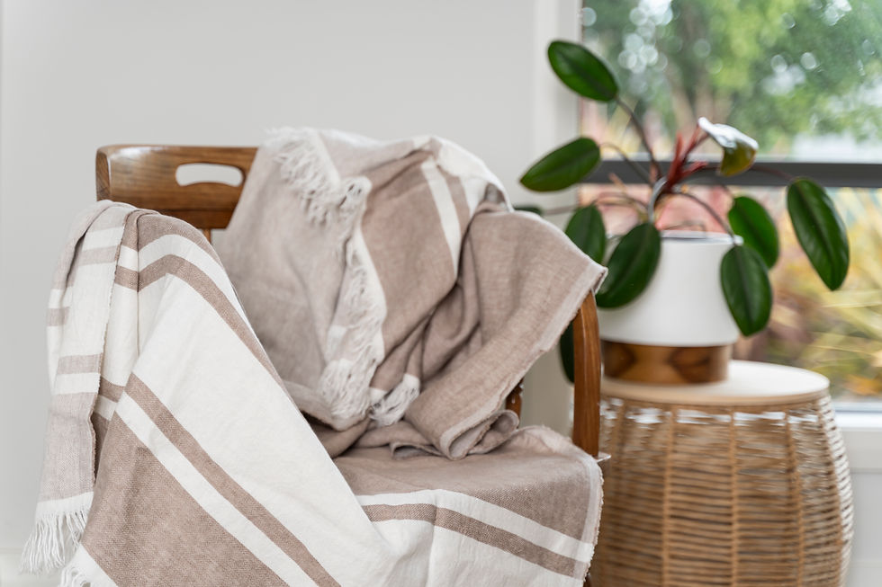 Thumbnail: Cappuccino striped 100% linen throw rug on a wooden chair next to a coffee table with a plant 
