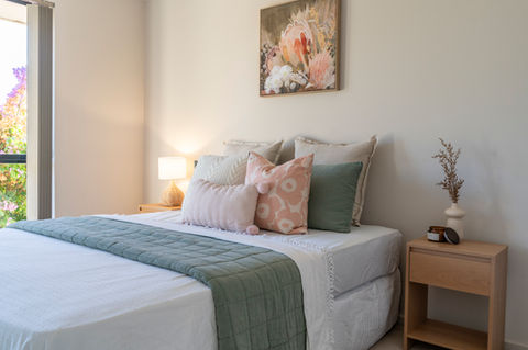Bedroom staged in greens, whites and pinks.