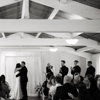 A picture of a bride and groom kissing at an indoor wedding