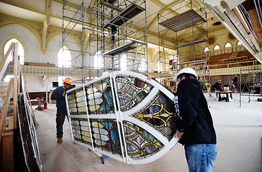 Crews install restored stained glass win