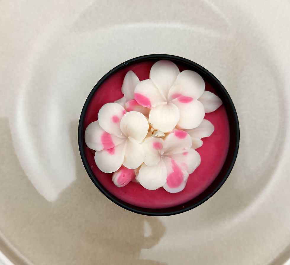 Bougie nomade Un soupçon de Douceur et de Cerise Noire dans une boîte ronde noire, décorée de fleurs blanches et roses