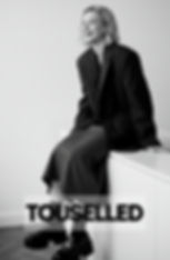 smiling woman with french lob hairstyle sitting on top of a table