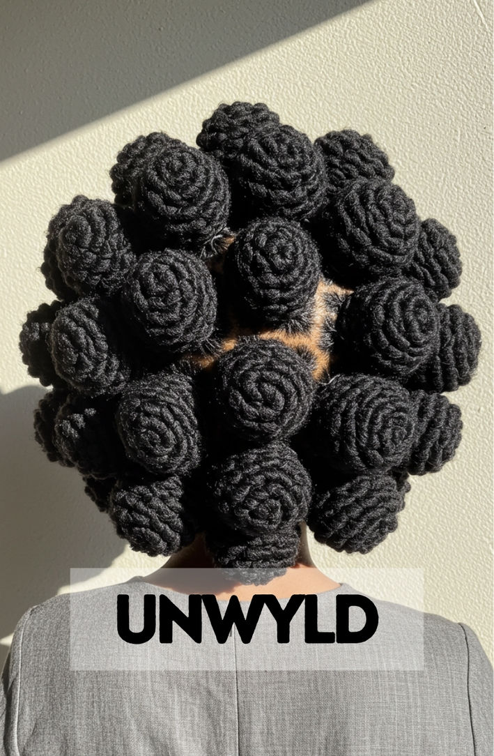 A woman with her box braids creatively styled into multiple, edgy Bantu knots.