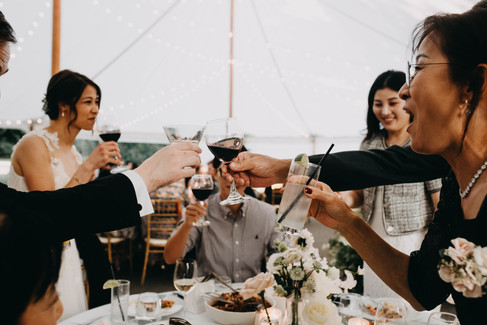 couple cheers with friends and family during June wedding