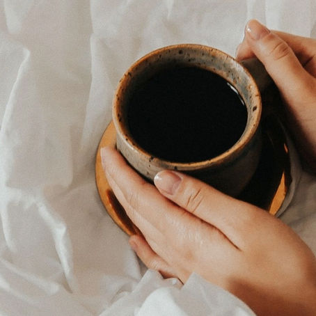 manos tomando una taza de cafe para bienestar