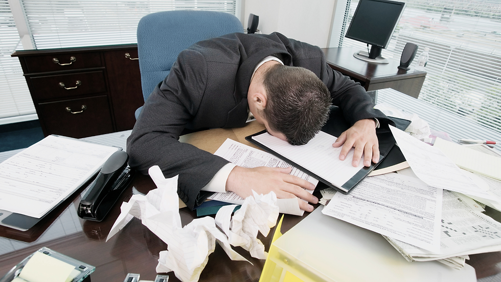 exhausted man at office desk corporate job