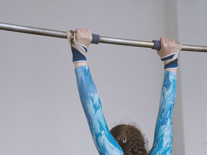 Turnerin greift nach der Stange