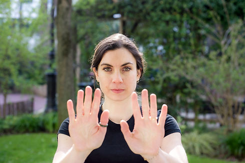 Femme coach en self-défense avec les paumes levées, elle dit stop et met de la distance. Elle a le regard affirmé.