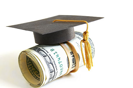 mini graduation cap on a roll of money.j