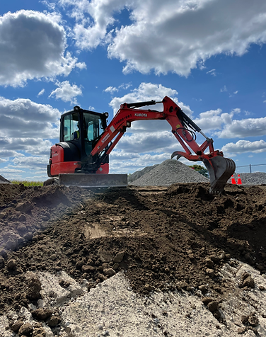 Excavator performing large-scale soil grading for sod installation at Old Elm GO Station in Stouffville.