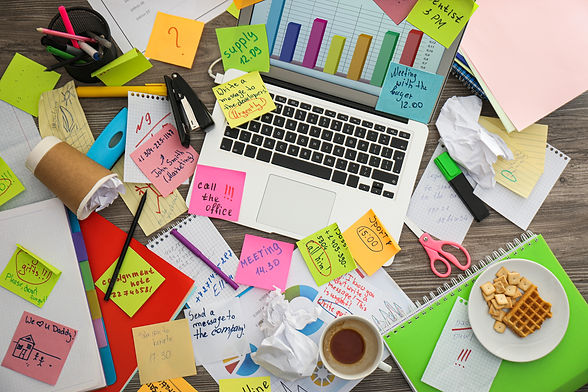 Laptop, notes and office stationery in mess on desk, top view Overwhelmed with work.jpg