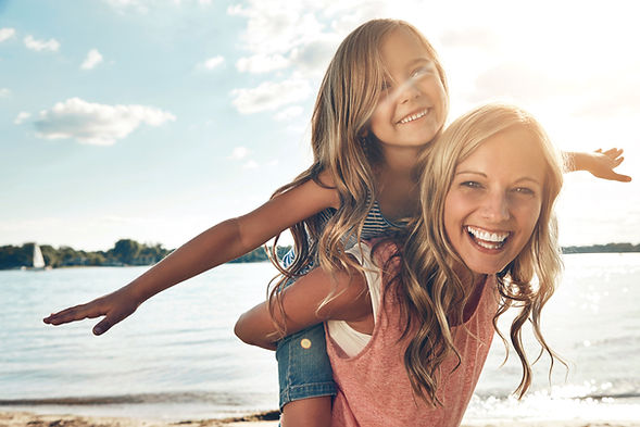 Portrait, mother and child on beach with piggyback, smile and playing on adventure holiday