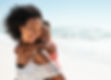 Smiling young black mother and beautiful daughter having fun on the beach with copy space