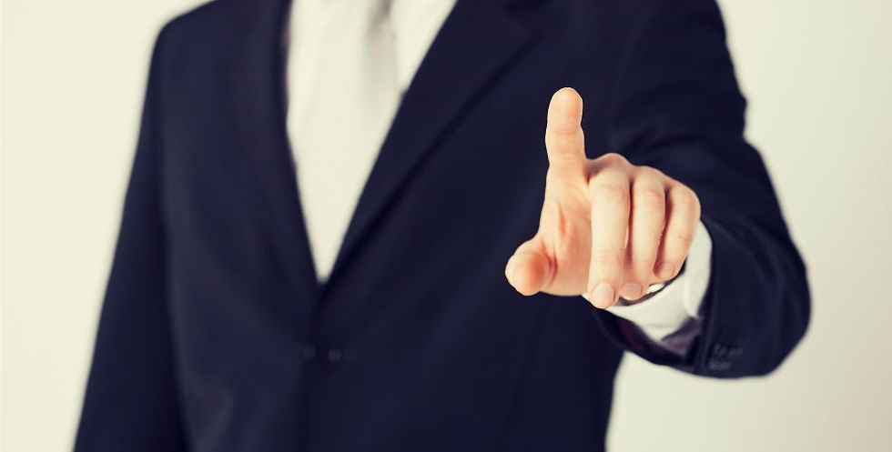 Person in a suit pointing directly forward, symbolising authority or instruction.