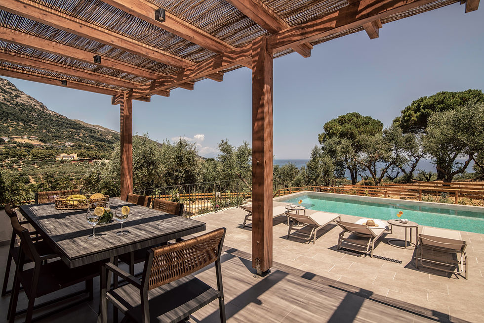 Close-up view of a shaded outdoor dining table beside a Greek villa pool