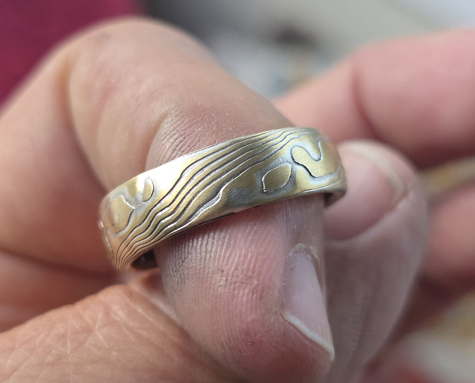Close-up view of a custom mokumegane ring showcasing intricate layered metal patterns