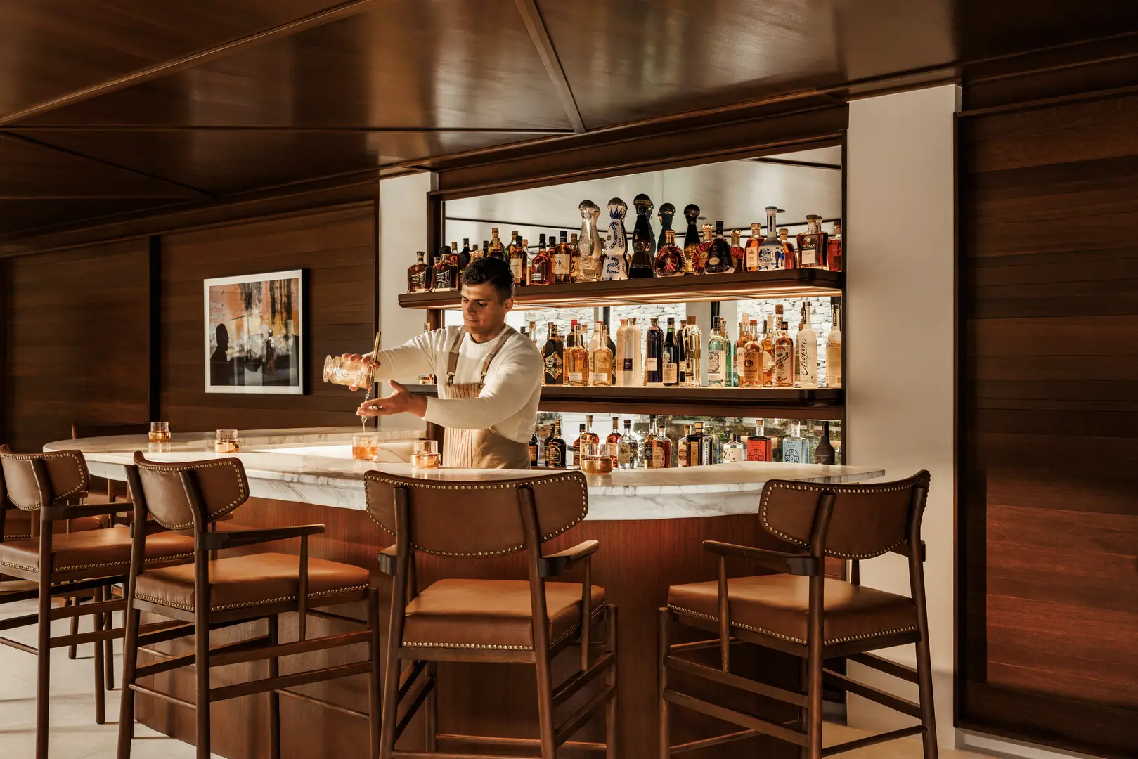 Stilren bar med en bartender som gör en drink One&Only Kéa Island