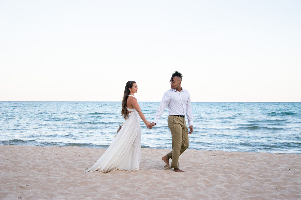 groom leading bride across sand beach at blue hour — wedding photography by Shutter & Sojourn
