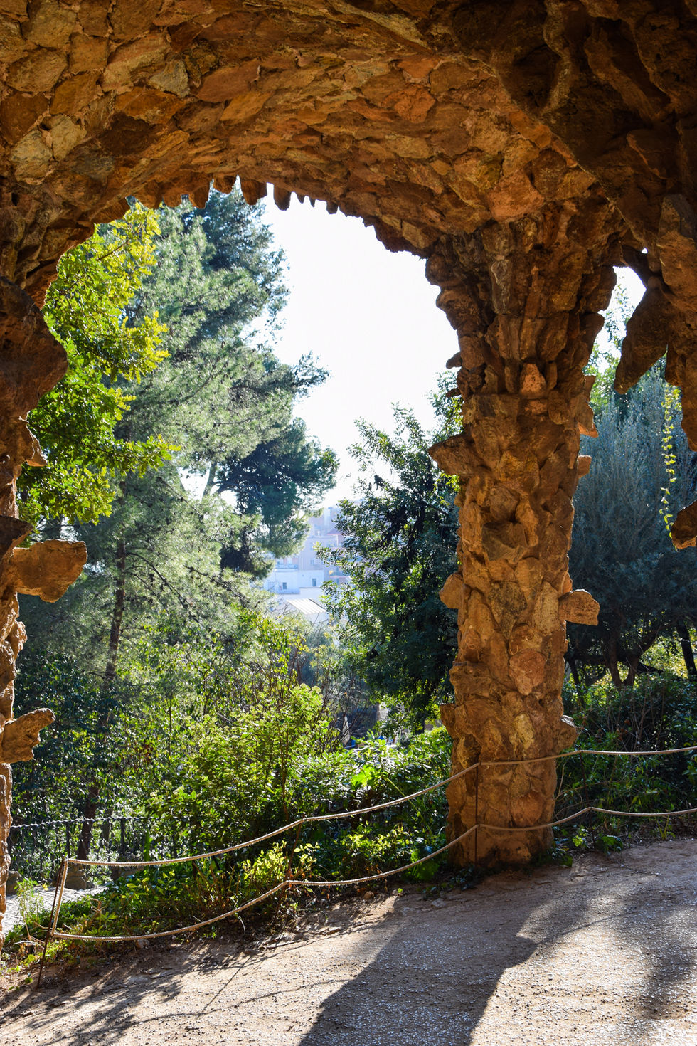 stone archway overlooking green forest at a park in Barcelona — travel photography by Shutter & Sojourn