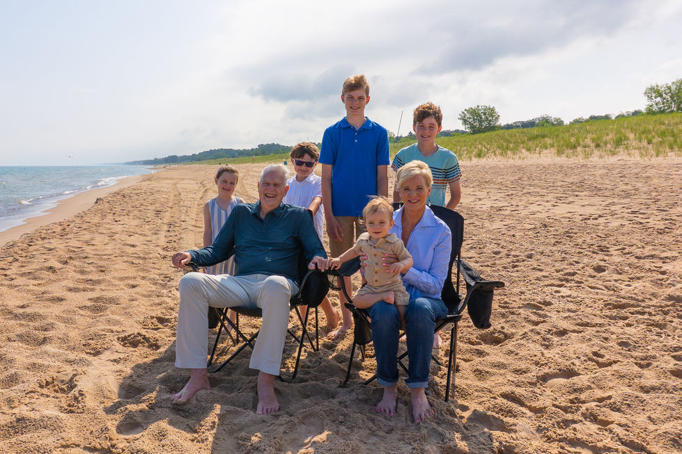 grandparents and grandchildren sitting in chairs on the beach