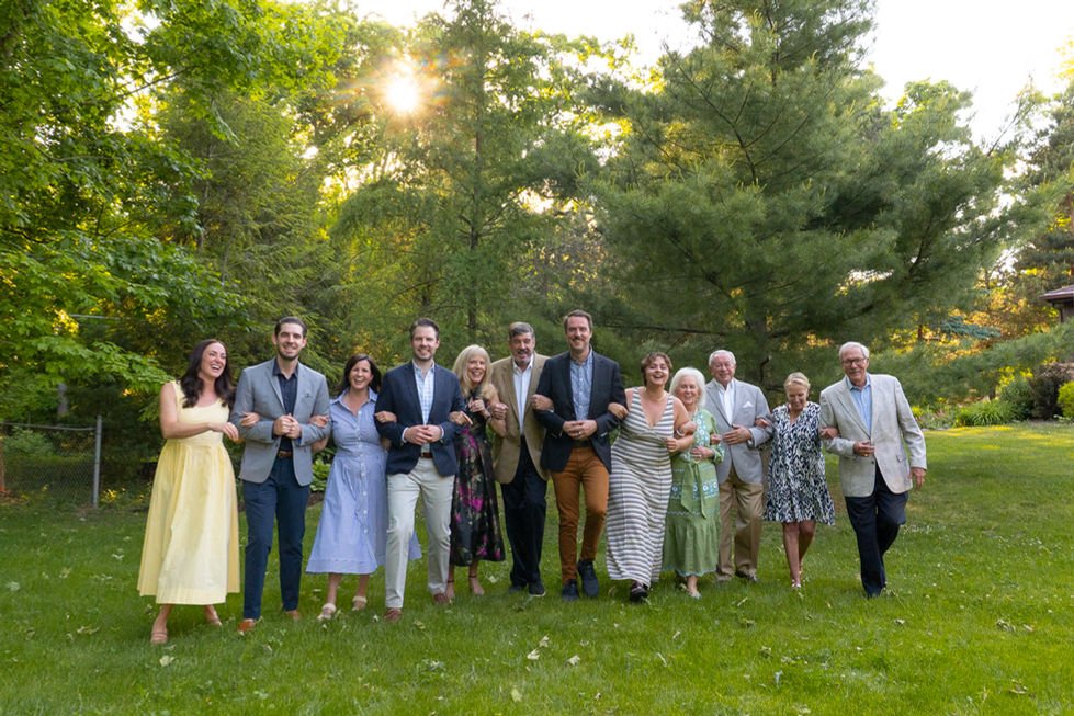 multi-generation family all linking arms and laughing
